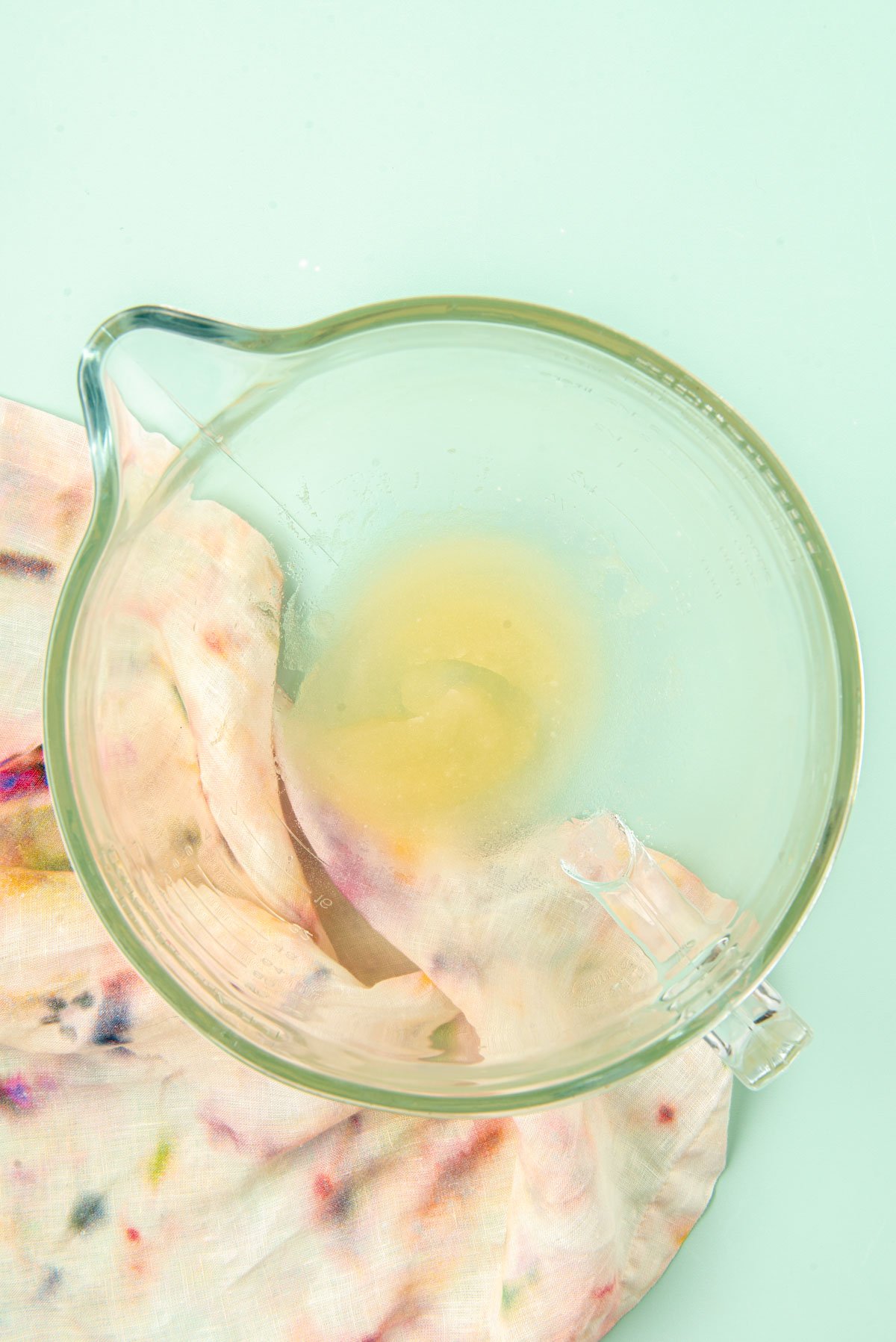 Gelatin and water in a glass mixing bowl.