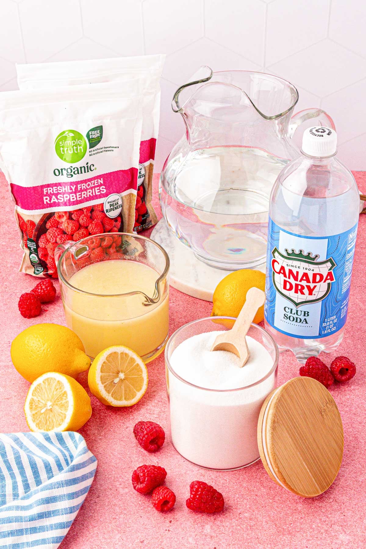 Ingredients to make raspberry lemonade on a table.