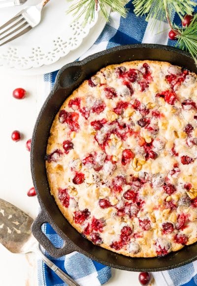 This Cranberry Cake combines sweet and tart in a delicious holiday dessert bursting with fresh red berries! A simple, old fashioned, single layer cake baked right in a skillet!