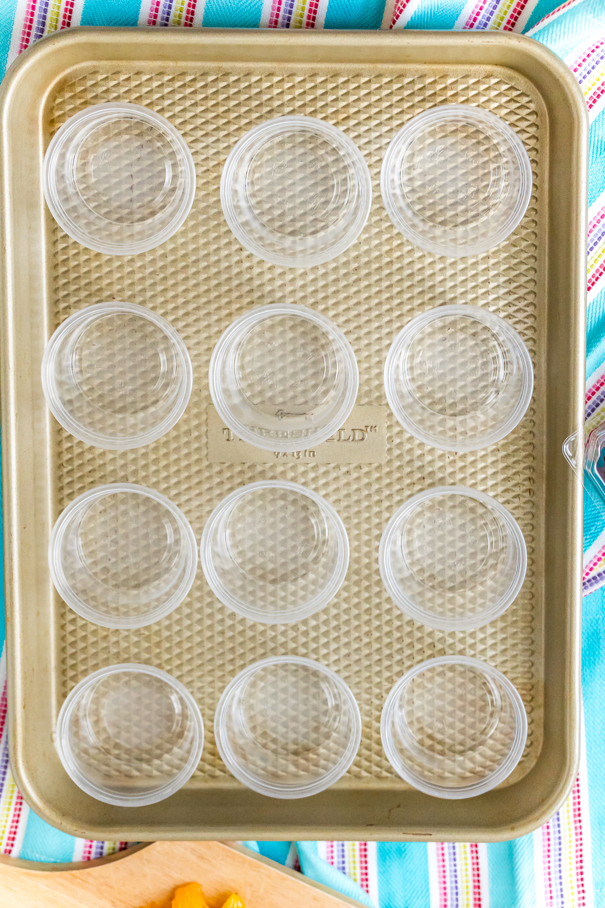 Condiment cups on a baking sheet ready to make jello shots.