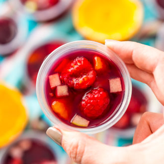 Woman's hand holding a sangria jello shot.