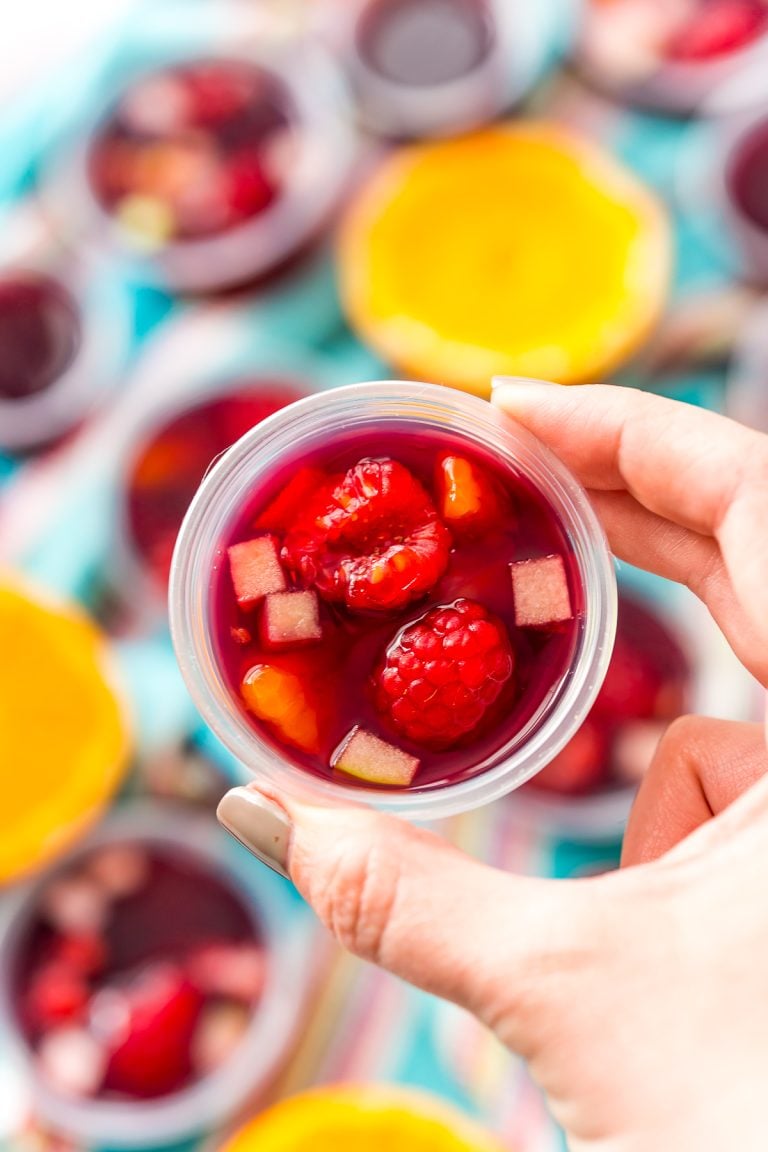 Woman's hand holding a sangria jello shot.