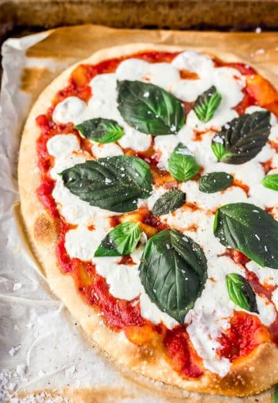A Classic Margherita Pizza made with delicious dough, olive oil, crushed tomatoes, garlic, mozzarella, and basil always hits the spot when you need a quick and easy dinner recipe!