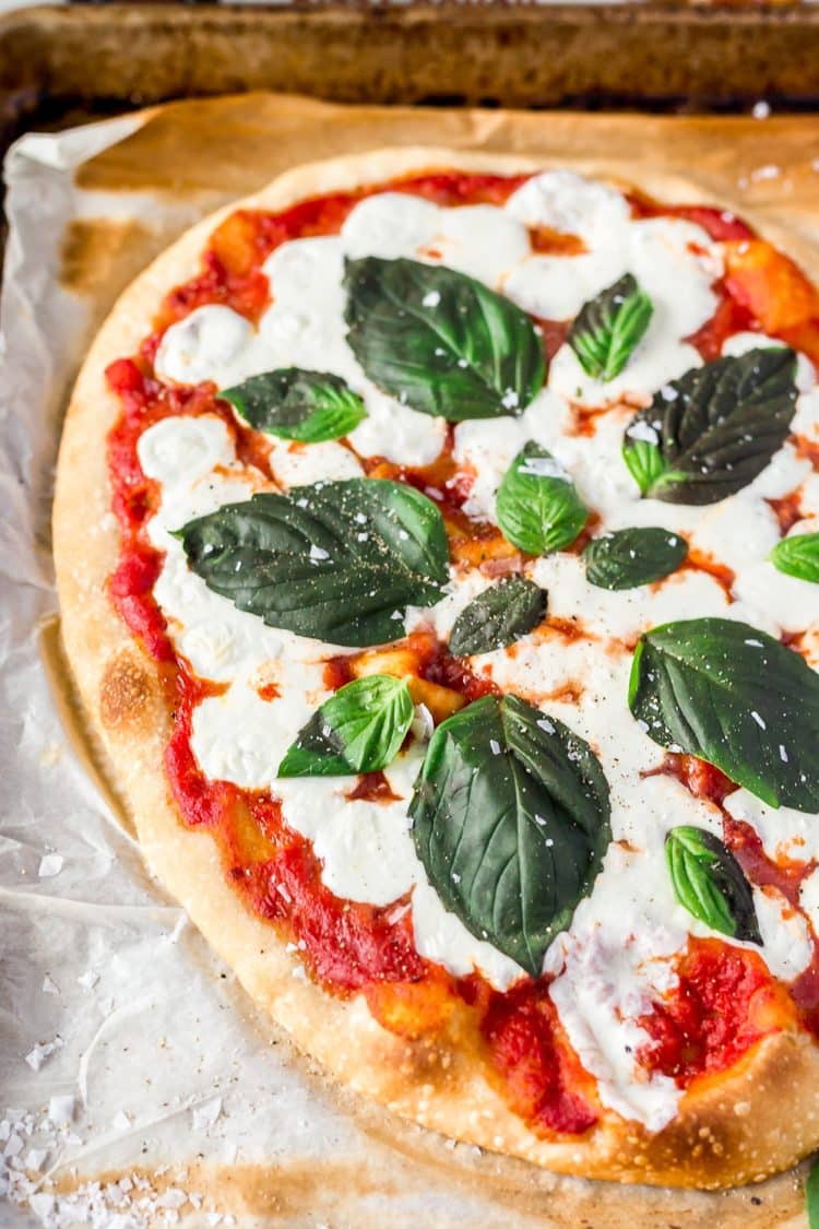 A Classic Margherita Pizza made with delicious dough, olive oil, crushed tomatoes, garlic, mozzarella, and basil always hits the spot when you need a quick and easy dinner recipe!