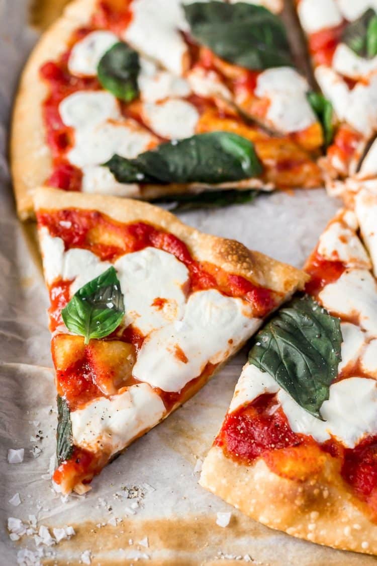 A Classic Margherita Pizza made with delicious dough, olive oil, crushed tomatoes, garlic, mozzarella, and basil always hits the spot when you need a quick and easy dinner recipe!