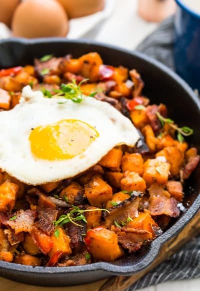 This Sweet Potato Hash is loaded with onions, peppers, bacon, and seasonings and topped with eggs for a delicious and hearty breakfast recipes!
