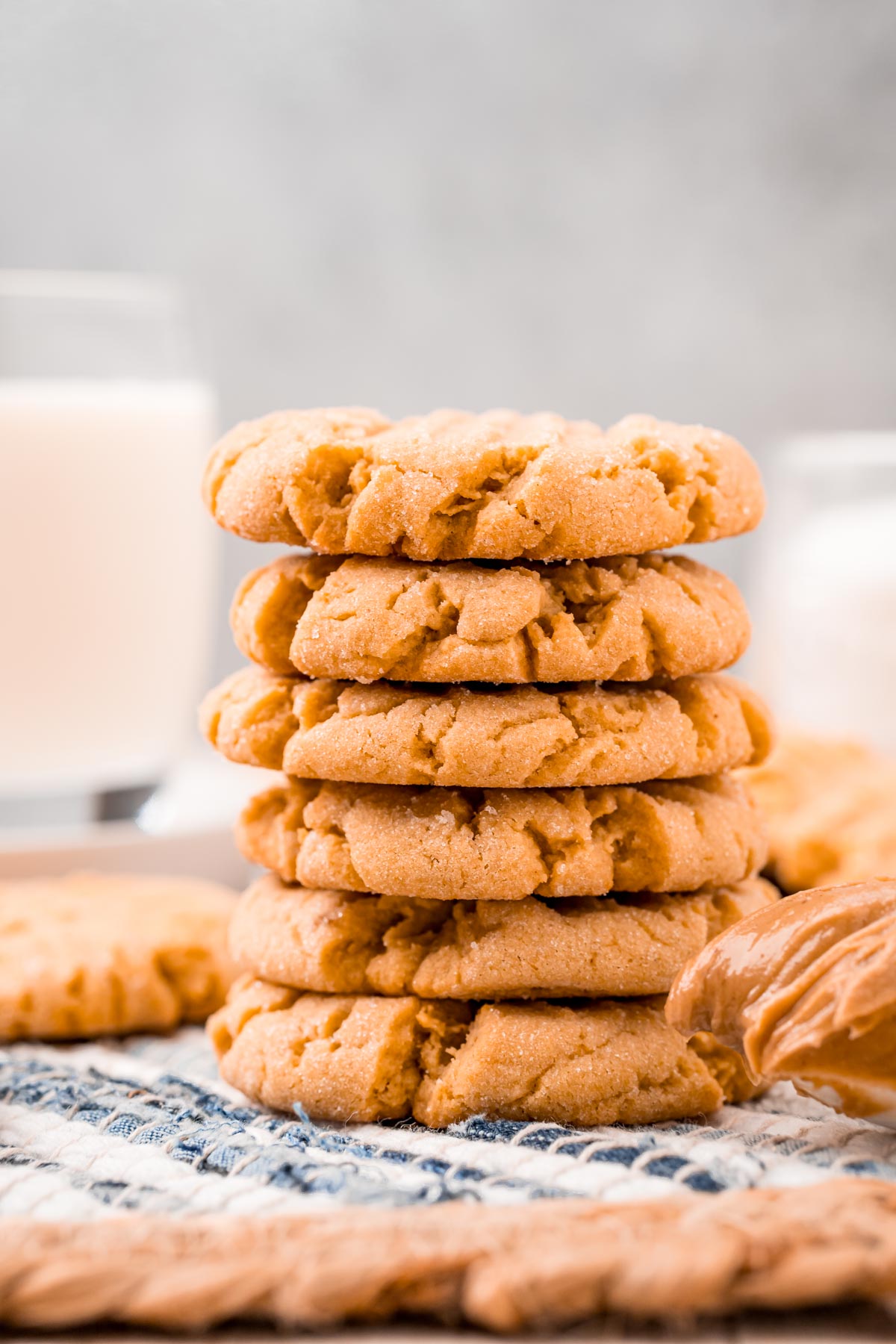 Straight on shot of a stack of 6 peanut butter cookies on a striped placemat.