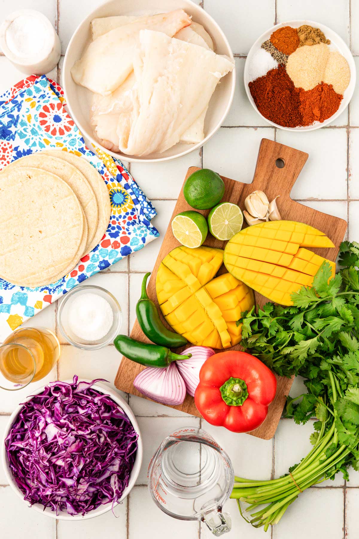 Overhead photo of ingredients to make fish tacos on a table.