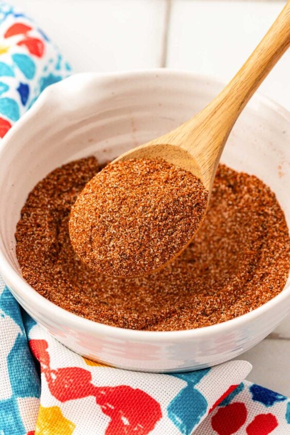 Fish taco seasoning in a bowl with a wooden spoon.