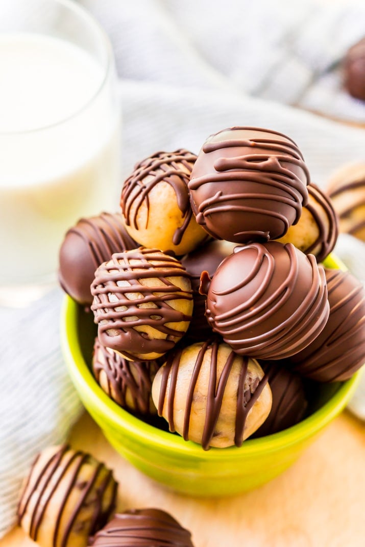 A small green bowl filled with cookie dough truffles.