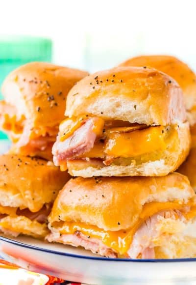 This Ham and Cheese Sliders Recipe is the ultimate EASY game day dish or weeknight dinner! Made with simple, family-favorite ingredients, these sliders made with honey ham and melted cheddar cheese will have everyone begging for seconds!