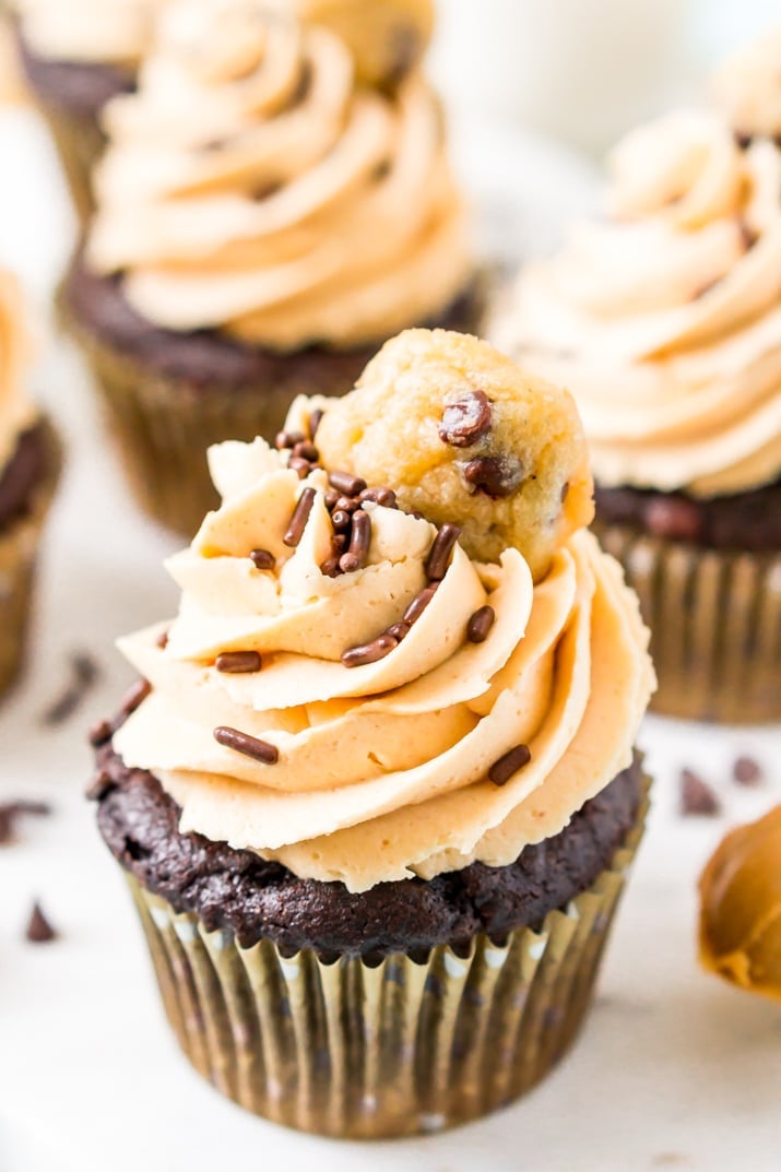 These Cookie Dough Cupcakes are made by stuffing an edible cookie dough into moist chocolate cupcakes and then topping it with a velvety peanut butter frosting, sprinkles, and a mini chocolate chip cookie!