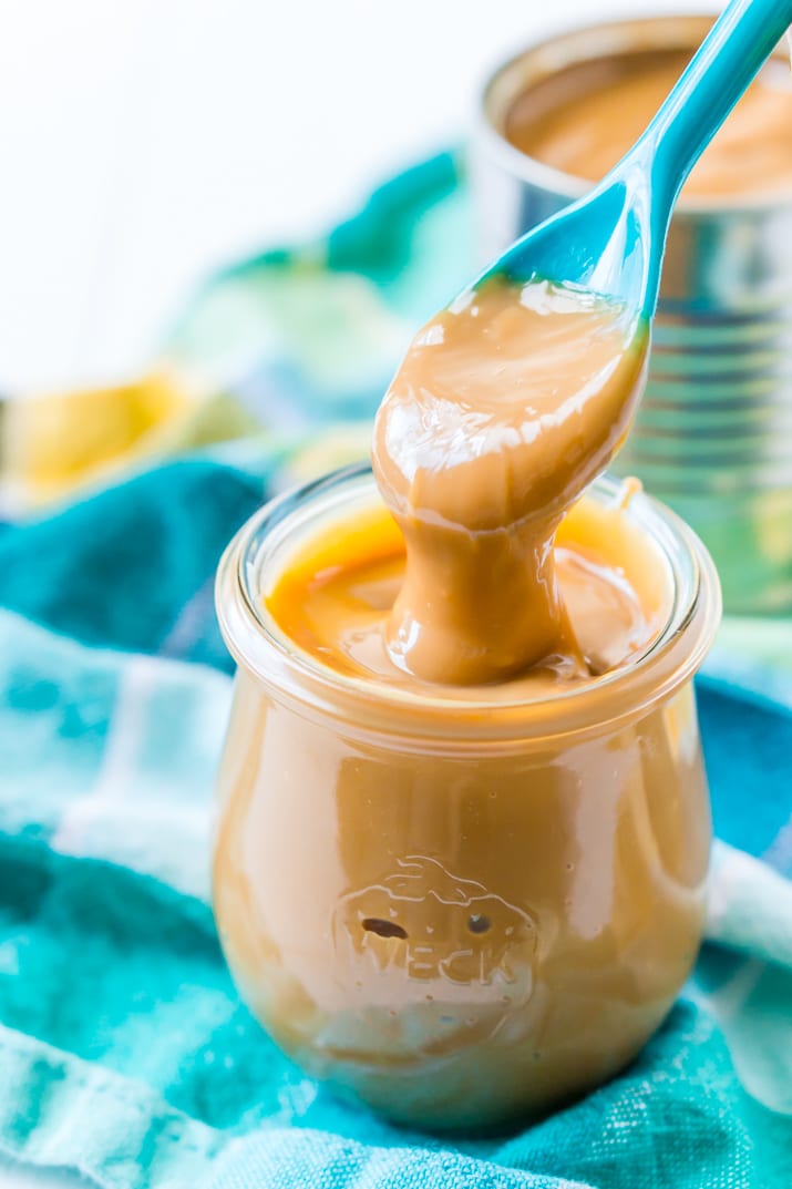 Homemade Dulce de leche in jar with spoon