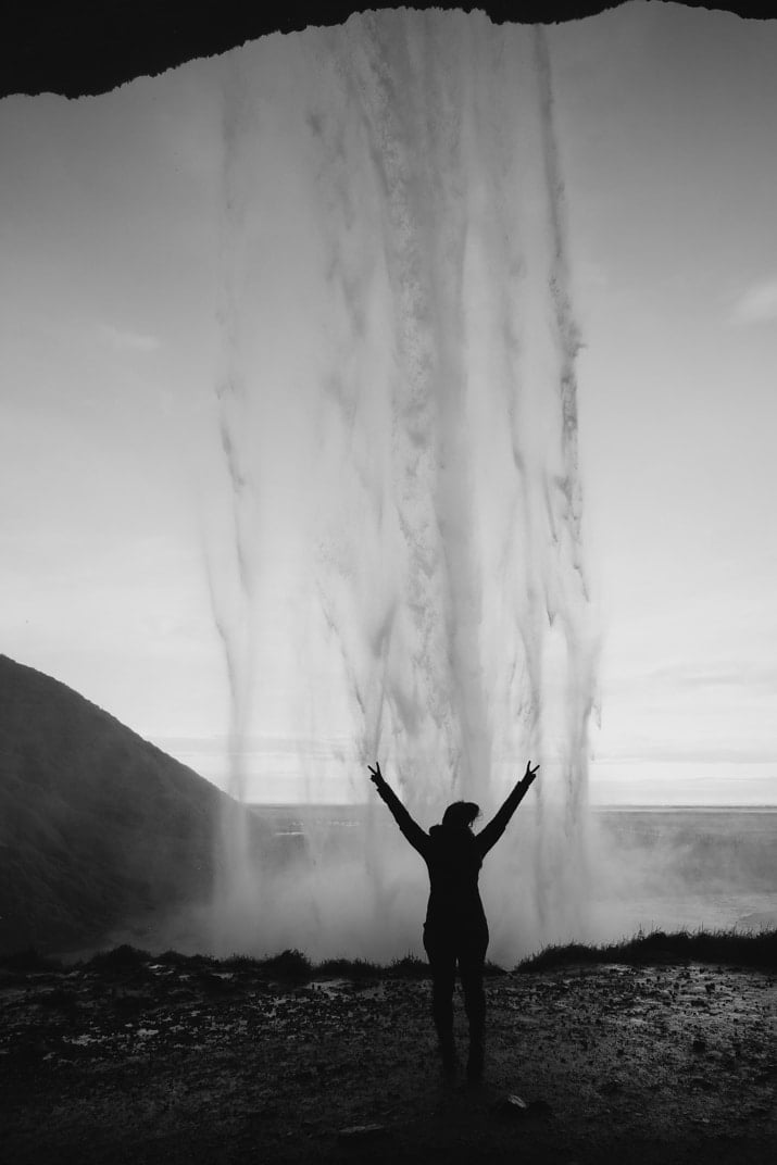 Girl under waterfall in Iceland