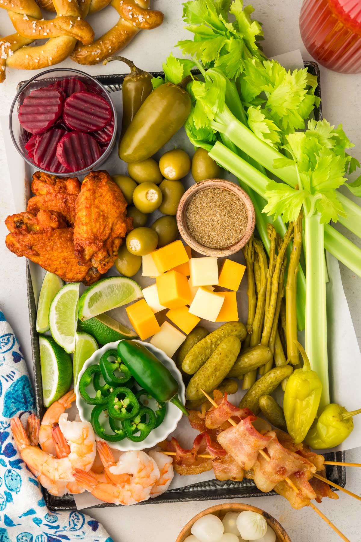 Overhead photo of a board of garnishes to use in Bloody Mary's.