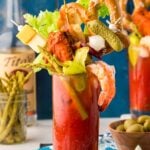 A glass filled with a Bloody Mary topped with extravagant garnishes for brunch.