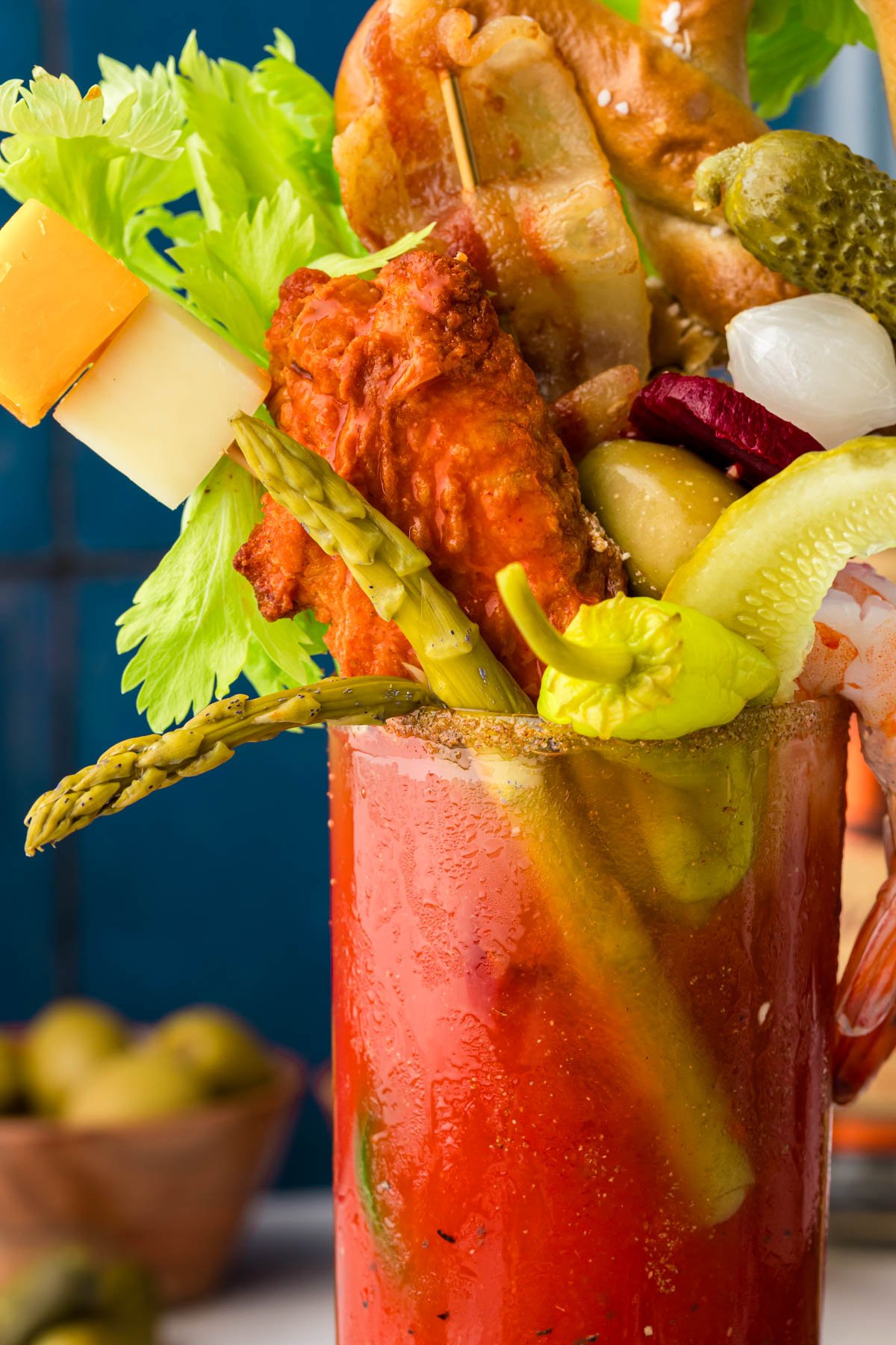 Close up of a glass of bloody mary with fun garnishes.