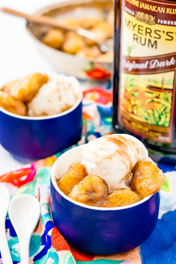 Bananas Foster in Blue Bowl with Bottle of Rum.