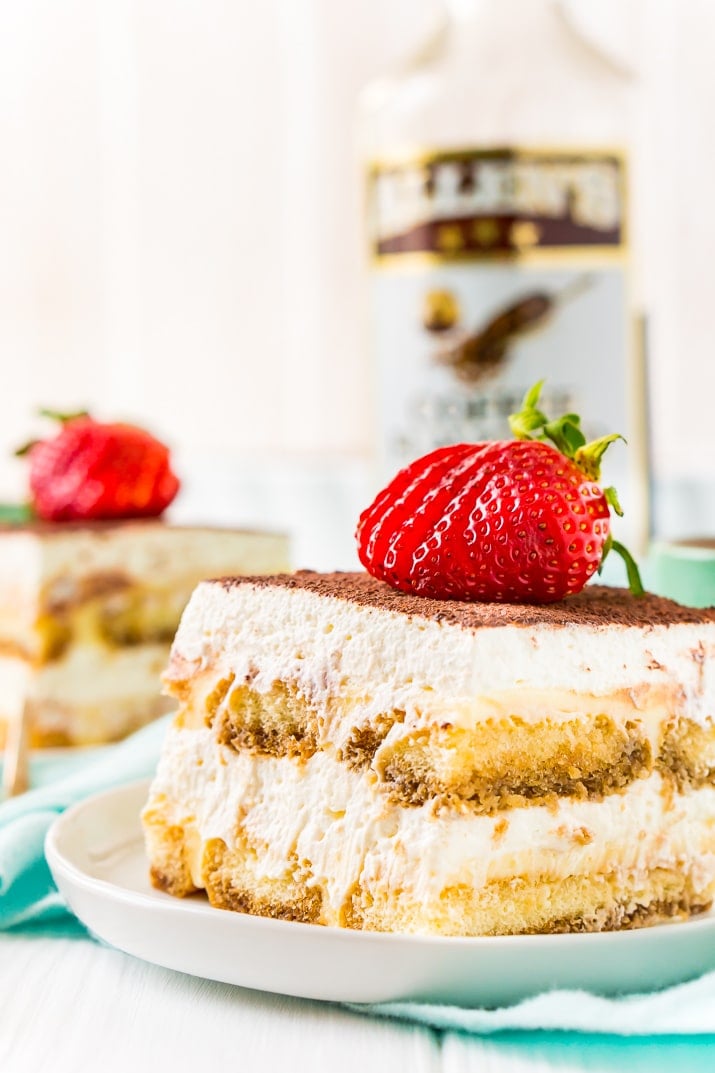 Tiramisu on Plate with Coffee Liqueur Bottle and Strawberry