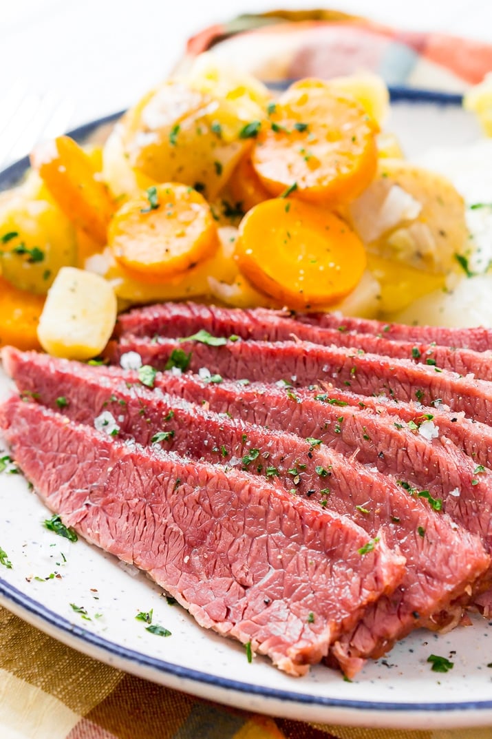 Corned beef and cabbage with carrots and potatoes on plate.