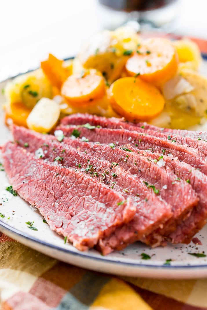 Corned beef with side of carrots and potatoes on plate