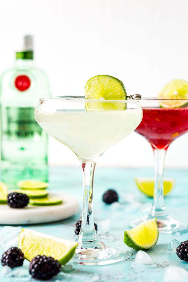 Classic gimlet and blackberry gimlet with limes and blackberries on the table.