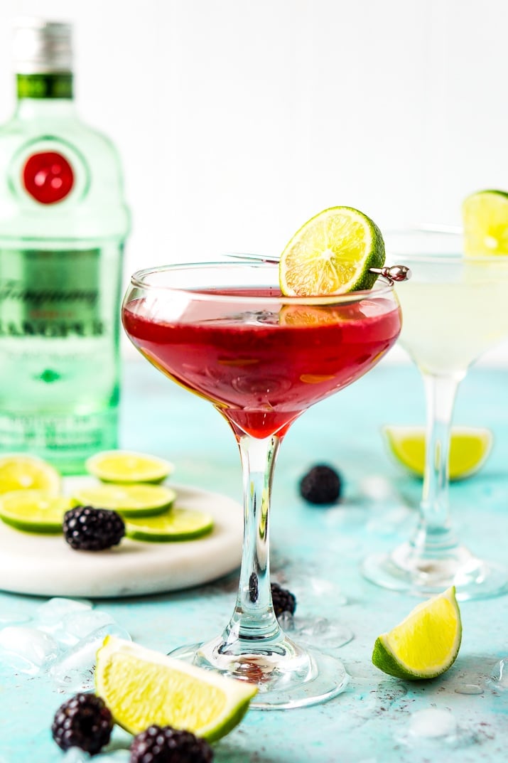 Blackberry Gimlet with bottle of gin in background