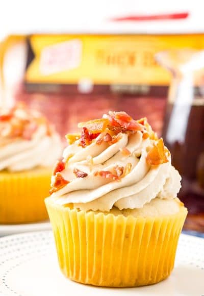 Coffee Maple Bacon Cupcakes consist of maple-infused vanilla cupcakes loaded with pieces of freshly cooked bacon. These treats are topped with a generous swirl of coffee-flavored whipped cream!