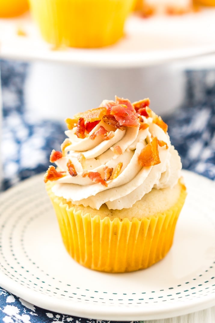 Coffee Maple Bacon Cupcakes consist of maple-infused vanilla cupcakes loaded with pieces of freshly cooked bacon. These treats are topped with a generous swirl of coffee-flavored whipped cream!