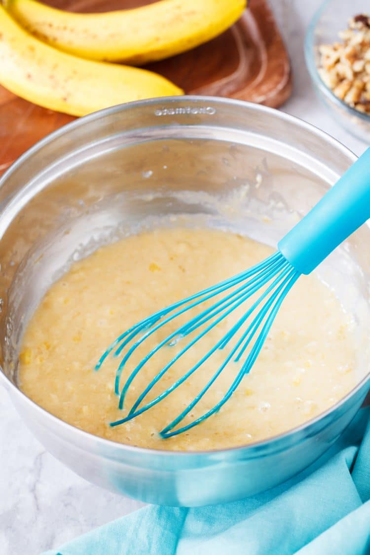 Banana bread batter in bowl with whisk