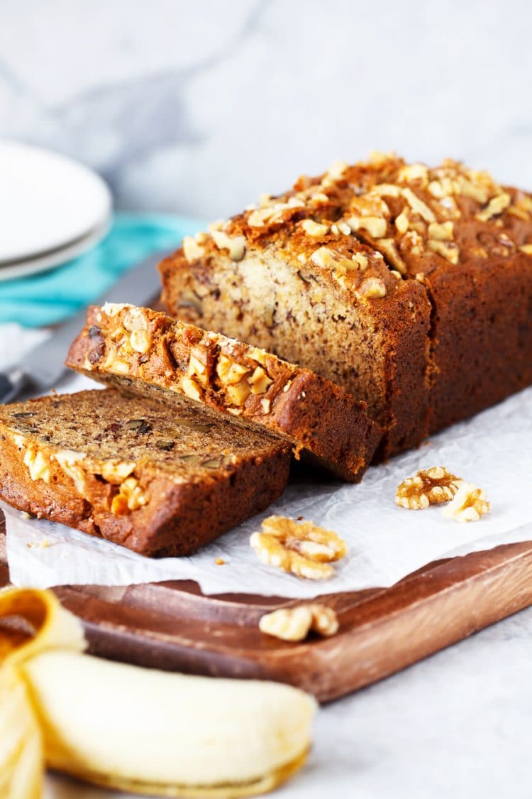 Loaf of banana bread sliced on cutting board