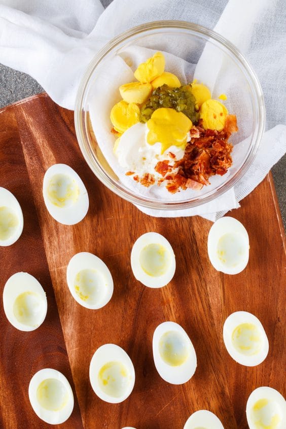 Prepping deviled eggs with mixing bowl and cutting board.