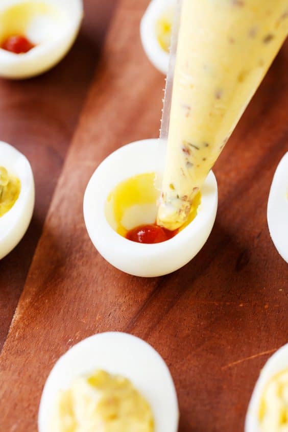 Filling deviled eggs with spicy egg yolk mixture