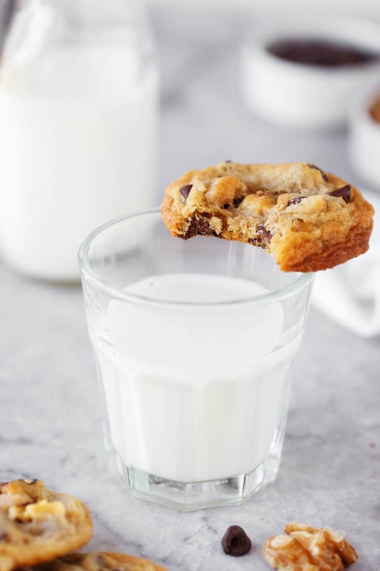 Toll House Cookie with bite out of it on glass of milk