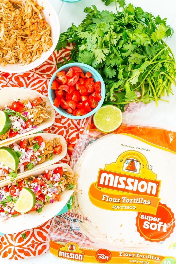 These Shredded Chicken Tacos are an easy and flavorful dinner to enjoy with friends and family. The chicken is loaded with spices and topped with fresh veggies and cheese all wrapped in a super soft flour tortilla.