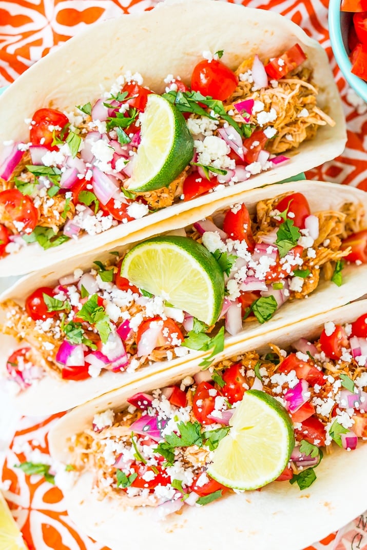 These Shredded Chicken Tacos are an easy and flavorful dinner to enjoy with friends and family. The chicken is loaded with spices and topped with fresh veggies and cheese all wrapped in a super soft flour tortilla.
