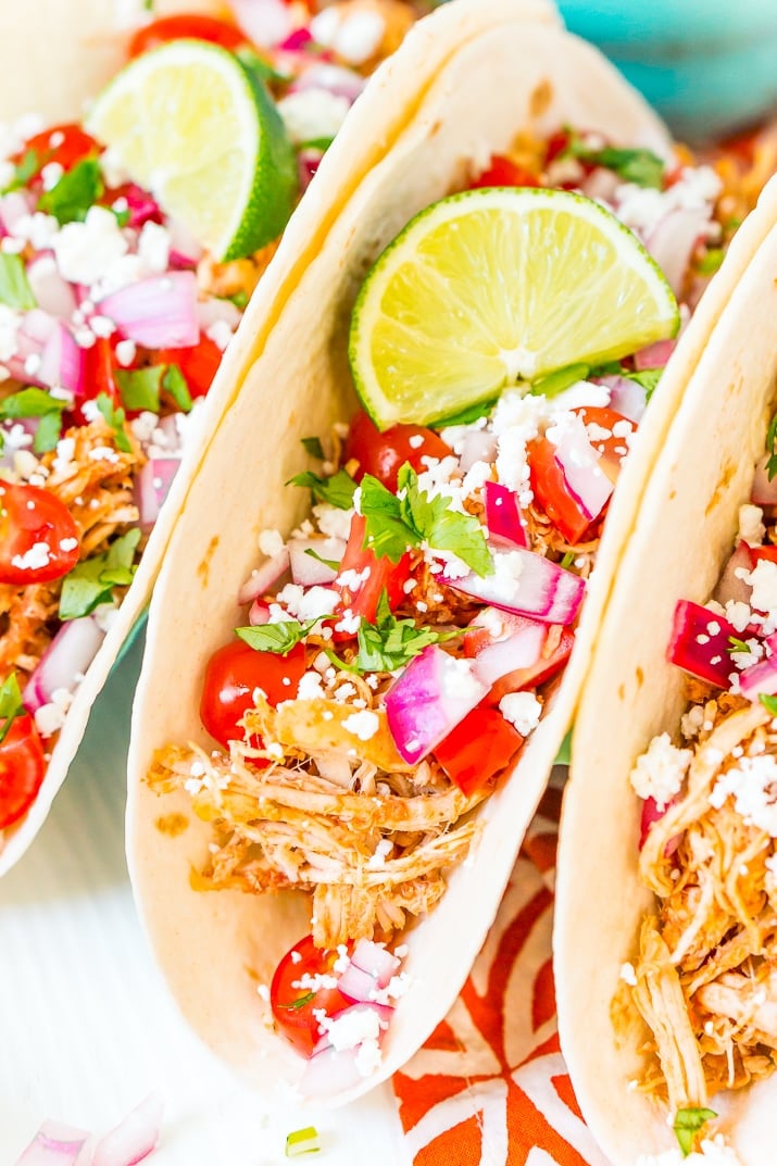 These Shredded Chicken Tacos are an easy and flavorful dinner to enjoy with friends and family. The chicken is loaded with spices and topped with fresh veggies and cheese all wrapped in a super soft flour tortilla.