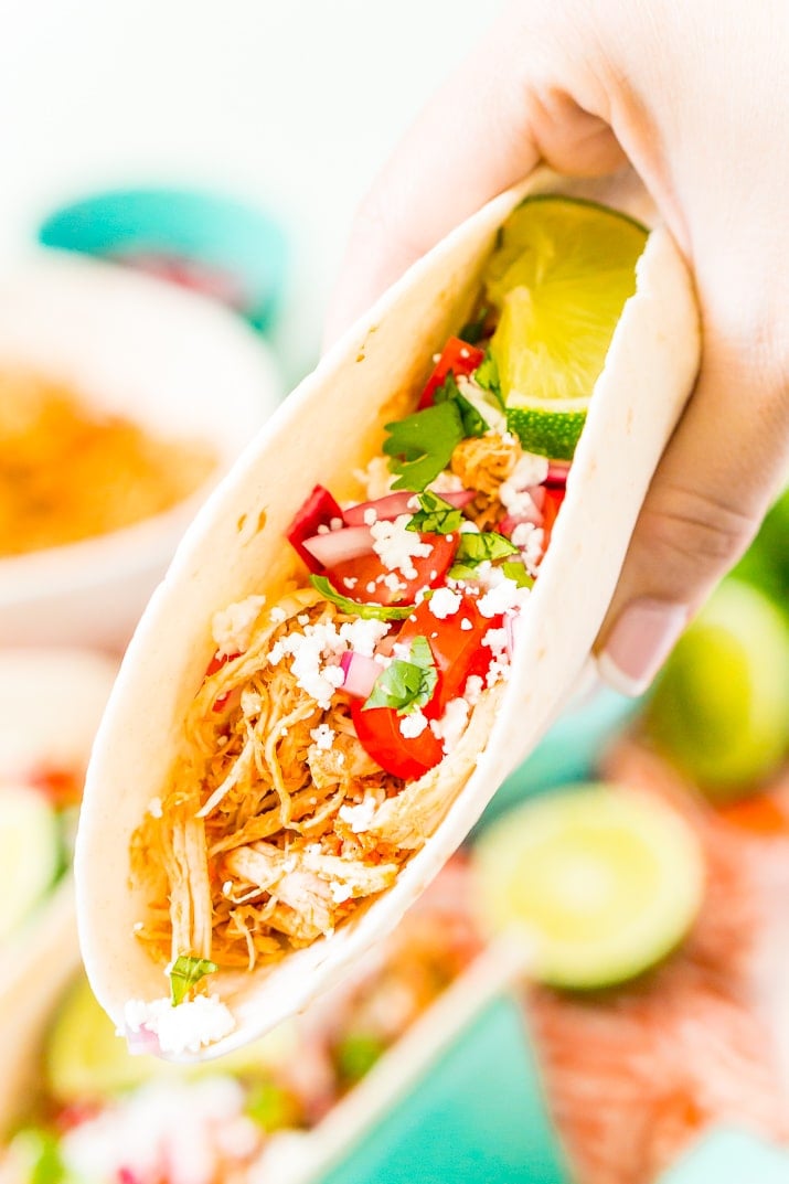 These Shredded Chicken Tacos are an easy and flavorful dinner to enjoy with friends and family. The chicken is loaded with spices and topped with fresh veggies and cheese all wrapped in a super soft flour tortilla.