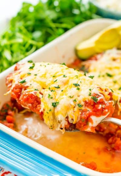 Close up photo of a serving spoon lifting a piece of salsa chicken out of a baking dish.