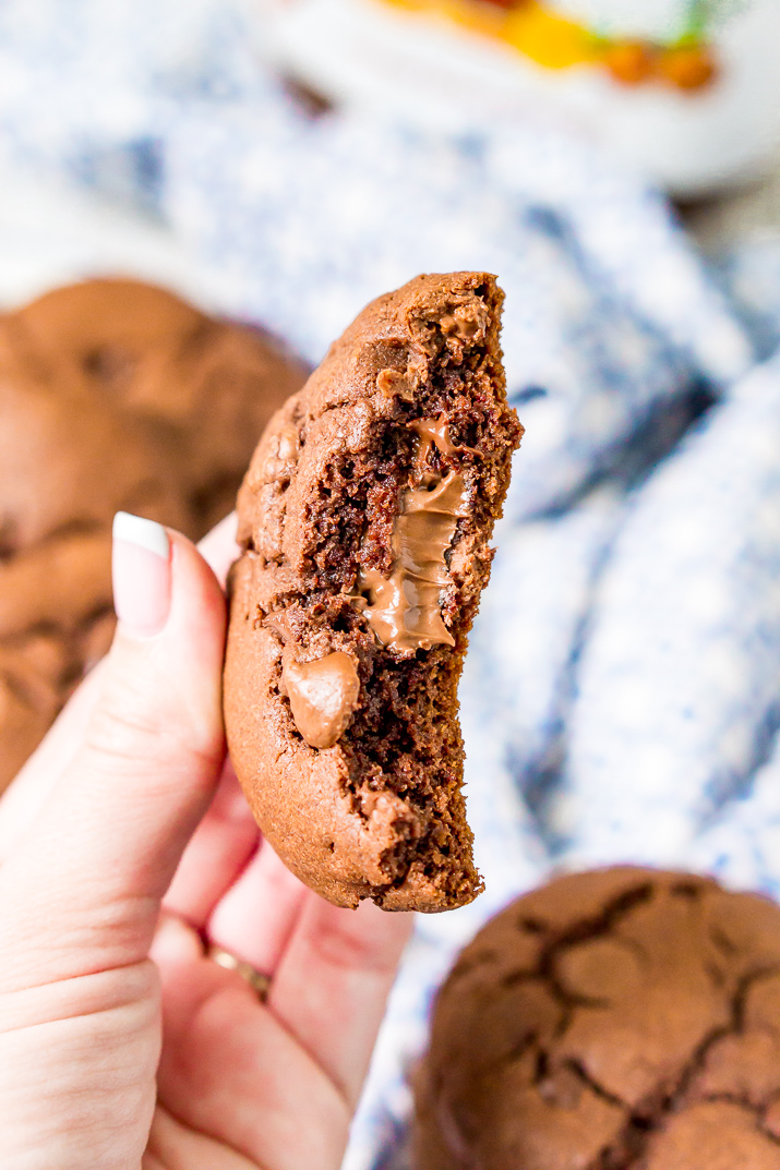 A Nutella stuffed cookie broken in half in a woman's hand.