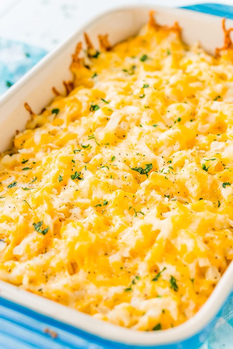 Close up photo of hashbrown casserole in a blue baking dish.