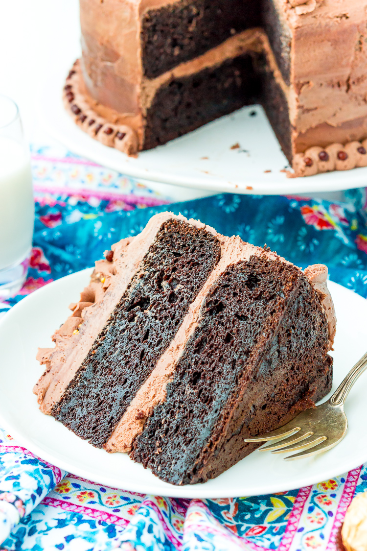 A slice of nutella cake on a white plate with a fork next to it.