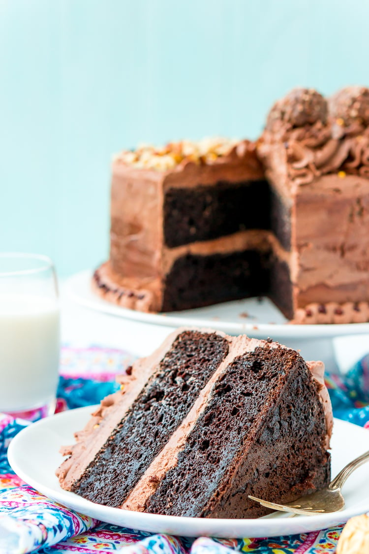 A slice of nutella cake on a white plate with a fork next to it.