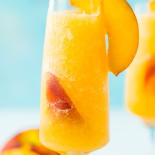 This Peach Bellini Slushies recipe is a frozen take on the classic brunch cocktail! Made in the blender with just 4 ingredients, this easy champagne cocktail is a refreshingly boozy beverage to enjoy all summer.