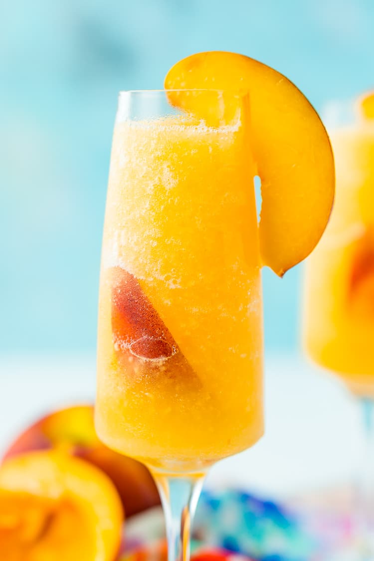 This Peach Bellini Slushies recipe is a frozen take on the classic brunch cocktail! Made in the blender with just 4 ingredients, this easy champagne cocktail is a refreshingly boozy beverage to enjoy all summer.