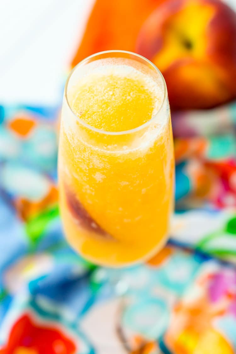 This Peach Bellini Slushies recipe is a frozen take on the classic brunch cocktail! Made in the blender with just 4 ingredients, this easy champagne cocktail is a refreshingly boozy beverage to enjoy all summer.