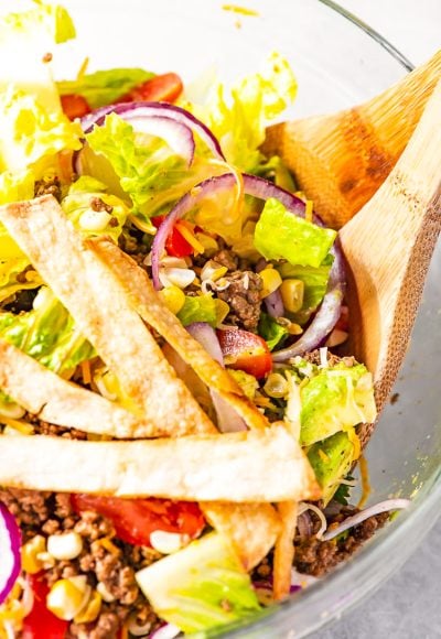 Taco Salad is the easiest way to rock Taco Tuesday like a pro! It's loaded with fresh veggies, cheese, and seasoned meat with crunchy tortilla strips! Whether you're meal-prepping or looking for a quick weekday dinner, this recipe is a real crowd pleaser.