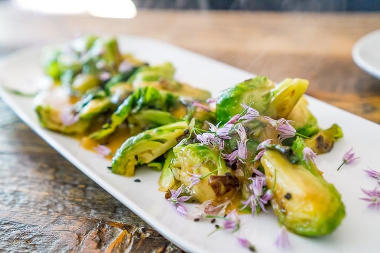 Roasted Brussel Sprouts on a platter with sauce