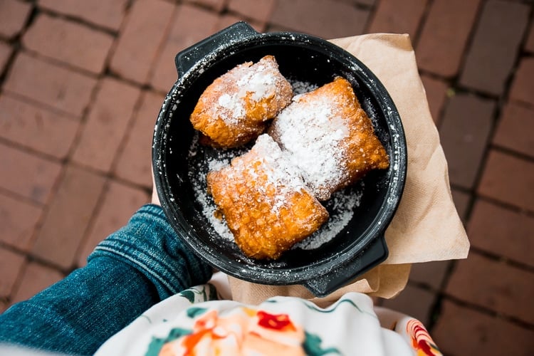 Beignets with powdered sugar in a pan. 