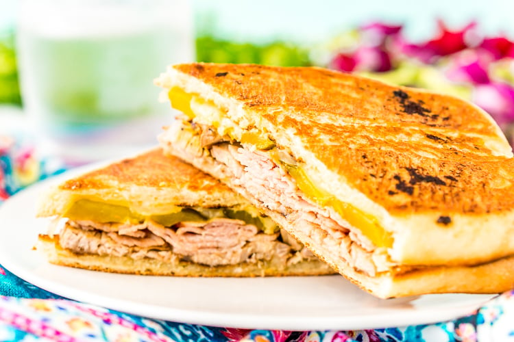 This Cuban Sandwich is loaded with smoked ham, swiss cheese, mojo pork, mustard, and pickles, and then grilled to melty perfection!